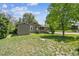 Expansive backyard with lush lawn, mature trees, and a view of the house exterior at 180 S Lamar St, Lakewood, CO 80226