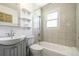 Cozy bathroom with tiled shower and tub, vanity, and built-in shelving at 180 S Lamar St, Lakewood, CO 80226