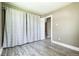 Neutral bedroom featuring wood-look flooring, neutral walls, and a large window with curtains for privacy at 180 S Lamar St, Lakewood, CO 80226