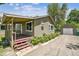 Home exterior with a charming covered porch, new landscaping, and detached garage at 180 S Lamar St, Lakewood, CO 80226