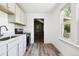Compact kitchen with stainless steel appliances, white cabinets, and a well-lit space next to a window at 180 S Lamar St, Lakewood, CO 80226