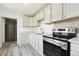 Updated kitchen featuring white cabinets, new appliances, and wood-look flooring at 180 S Lamar St, Lakewood, CO 80226