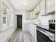 Charming kitchen with stainless steel appliances, white cabinets, and natural light from a window at 180 S Lamar St, Lakewood, CO 80226
