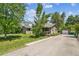 Large yard with home, detached garage, mature trees, and lush greenery at 180 S Lamar St, Lakewood, CO 80226