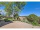 Brick patio with a privacy fence, mature trees, and landscaping at 547 S Flower St, Lakewood, CO 80226