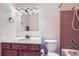 Cozy bathroom featuring a wood vanity, mirrored medicine cabinet, and tile shower and tub at 547 S Flower St, Lakewood, CO 80226
