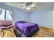 Cozy bedroom with a ceiling fan and a plush purple bedspread, offering a relaxing retreat at 547 S Flower St, Lakewood, CO 80226