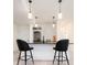 Basement bar with black countertop, brick backsplash, and stainless steel wine cooler adds a touch of modern sophistication at 8230 W Tennessee Ct, Lakewood, CO 80226