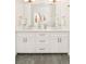 Bathroom vanity with dual sinks, white cabinets, marble countertop, and stylish gold hardware at 8230 W Tennessee Ct, Lakewood, CO 80226