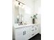 Bathroom featuring a large mirror, white cabinets, dark floors, and dual shower heads at 8230 W Tennessee Ct, Lakewood, CO 80226