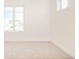 Empty bedroom showcases new carpet and a large window overlooking the neighborhood at 8230 W Tennessee Ct, Lakewood, CO 80226