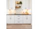 Bright kitchen featuring white cabinetry with bronze hardware and backsplash, plus wooden floating shelves at 8230 W Tennessee Ct, Lakewood, CO 80226
