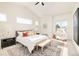 Bright main bedroom with large windows, ceiling fan, stylish decor, and ensuite bathroom access at 8230 W Tennessee Ct, Lakewood, CO 80226