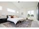 Airy primary bedroom featuring carpet, many windows, and modern decor at 8230 W Tennessee Ct, Lakewood, CO 80226