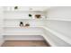 Spacious pantry with light wood floors and tiered white shelving to provide ample storage and organization at 8230 W Tennessee Ct, Lakewood, CO 80226