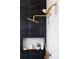 Luxurious shower stall featuring gold fixtures, tile work, and convenient shelving at 8230 W Tennessee Ct, Lakewood, CO 80226