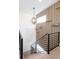 Stylish staircase with wood slat accent wall, decorative lighting, and metal railings at 8230 W Tennessee Ct, Lakewood, CO 80226
