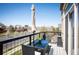 Balcony features wrought iron railings, an umbrella and outdoor seating with city views at 5677 S Park Pl # B310, Englewood, CO 80111