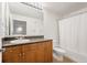 Well-lit bathroom features a vanity with granite countertop, wood cabinets and a shower-tub combo at 5677 S Park Pl # B310, Englewood, CO 80111