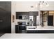 Modern kitchen featuring dark cabinetry, stainless steel appliances, and a spiral staircase nearby at 5677 S Park Pl # B310, Englewood, CO 80111