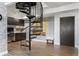 Home interior features a black spiral staircase with stone accent wall and hardwood floors at 5677 S Park Pl # B310, Englewood, CO 80111