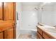 Bright bathroom with a shower/tub combo, tile surround, and wood vanity at 6310 W Sumac Ave, Littleton, CO 80123