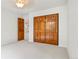 A well lit bedroom with natural wood doors and trim and neutral carpeting at 6310 W Sumac Ave, Littleton, CO 80123