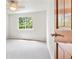 Neutral bedroom with plush carpet, bright window and a wooden door at 6310 W Sumac Ave, Littleton, CO 80123