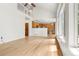 Open-concept living area featuring hardwood floors, vaulted ceiling, large windows, and seamless kitchen access at 6310 W Sumac Ave, Littleton, CO 80123