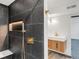 Close up of a modern bathroom with a walk-in shower featuring a gold shower head, seat, and dark tile at 8331 Oakwood St, Westminster, CO 80031