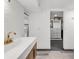 Bright bathroom featuring a modern vanity with gold fixtures, wavy accent tile, and walk-in closet at 8331 Oakwood St, Westminster, CO 80031