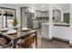 Open-concept dining area flowing into the kitchen, featuring a set table and stylish modern chairs at 8331 Oakwood St, Westminster, CO 80031