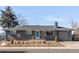 Charming single-story home with gray brick, a well-manicured front yard, and a welcoming blue front door at 8331 Oakwood St, Westminster, CO 80031