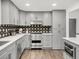 Modern kitchen with sleek gray cabinets, stainless steel appliances, and an eye-catching backsplash at 8331 Oakwood St, Westminster, CO 80031