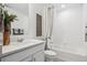 Bright bathroom with tiled shower-tub combo, vanity and modern decor at 940 Andrews Crest Dr, Berthoud, CO 80513