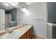 Bathroom featuring double sinks, a vanity with wood cabinets, and a shower with tub combo at 15700 E Jamison Dr # 3-307, Englewood, CO 80112