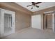 Bedroom featuring neutral carpet, a ceiling fan, a glass panel door, and a closet at 15700 E Jamison Dr # 3-307, Englewood, CO 80112