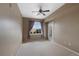 Bedroom featuring neutral carpet, a ceiling fan, a window, and a glass panel door at 15700 E Jamison Dr # 3-307, Englewood, CO 80112
