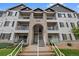 Exterior of a well maintained, three-story condo building showing walkways leading to unit front doors and balconies at 15700 E Jamison Dr # 3-307, Englewood, CO 80112
