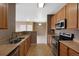 Kitchen showcasing stainless steel appliances, tile floors, and views into the living area at 15700 E Jamison Dr # 3-307, Englewood, CO 80112