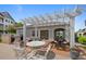 Inviting outdoor seating area with white pergola, grill, and charming decor for relaxing and entertaining at 15700 E Jamison Dr # 3-307, Englewood, CO 80112