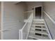 A well-lit condo building walkway with white rails lead to front doors at 15700 E Jamison Dr # 3-307, Englewood, CO 80112