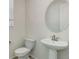 Compact half-bathroom with pedestal sink, oval mirror and toilet in a neutrally colored space at 434 N Old Hammer St, Aurora, CO 80018