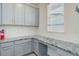 Well-lit office space with gray cabinets, speckled countertop, and a window providing natural light at 434 N Old Hammer St, Aurora, CO 80018