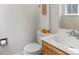 Cozy half bathroom with a wood vanity, white sink, toilet and decorative towels and sunflowers at 101 S Downing St # 8, Denver, CO 80209