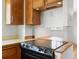Close up of the black glass top stove with light wood cabinets and cream colored countertop in the kitchen at 101 S Downing St # 8, Denver, CO 80209