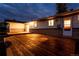 A raised wooden deck adjoins this house with a large back yard at dusk at 8895 Morton Rd, Niwot, CO 80503