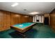 Finished basement with wood paneling, white brick fireplace, pool table, and carpet at 8895 Morton Rd, Niwot, CO 80503