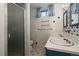 Cozy bathroom featuring a double vanity, walk-in shower, and patterned floor at 8895 Morton Rd, Niwot, CO 80503