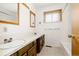 Bright bathroom featuring a double sink vanity with cabinets and a tub with tile surround at 8895 Morton Rd, Niwot, CO 80503